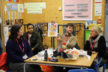 four teachers in a classroom showing their artwork