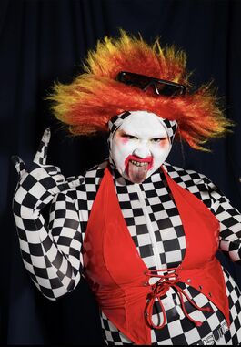 Su Mi dressed as a scary clown against a black background