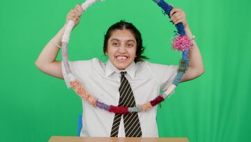 Girl plays with hoop in front of green screen 