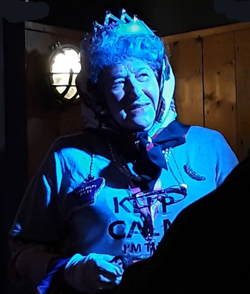 WhatsApp image of performer in action, dressed in tiara and headscarf
