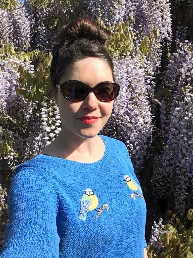 Elly wearing a blue jumper with hand embroidered birds 