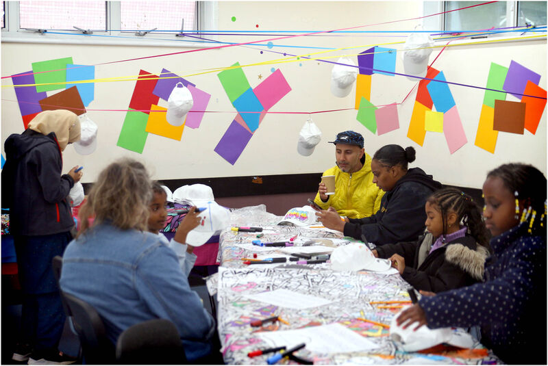 Young people designing their own Happy Caps , with colourful posters on the wall. 