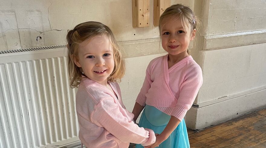 Two girls facing each other and holding hands getting ready to galop
