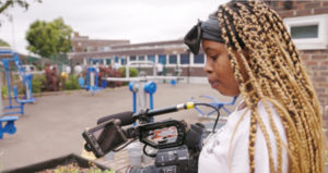 Girl looking down into camcorder 