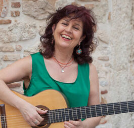 An Image Of A Smiling Woman Playing The Guitar