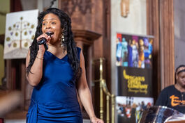 Woman in blue dress singing in a church