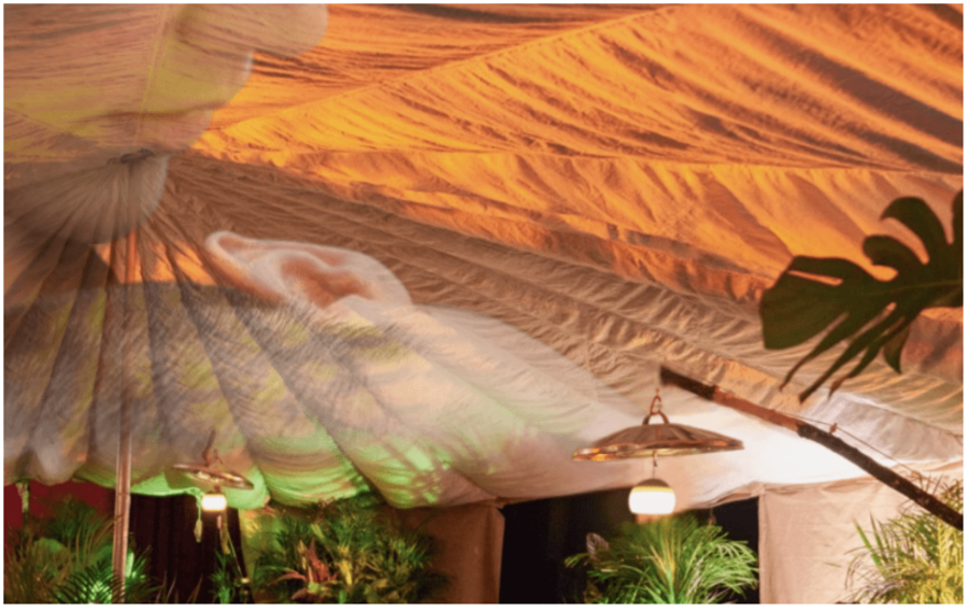 The inside of a yurt, lit up in shimmering colours.