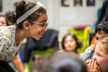 Two little girls grinning at each other