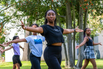 Woman leading children in dance outside