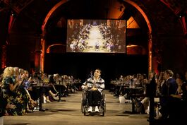 The picture shows actor George Robinson in a wheelchair, modelling on the catwalk at Front Row 2025