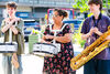 three musicians stand outside smiling