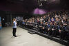 Theatre of school children facing woman on stage