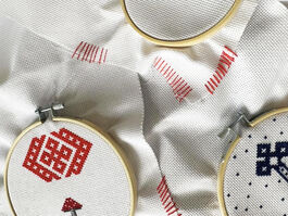 Three embroidery pieces with geometric patters on top of white fabric