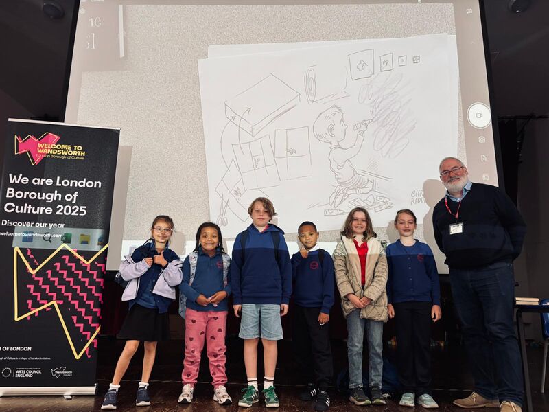 Chris Riddell and children in front of projector screen of drawings