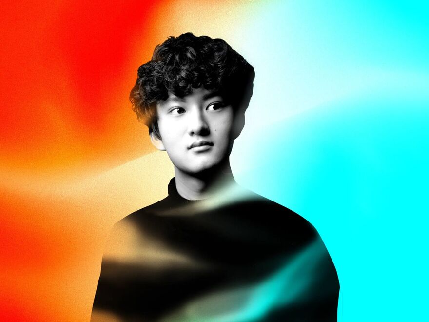 A black and white photograph of pianist Ryan Wang on a red and blue background.