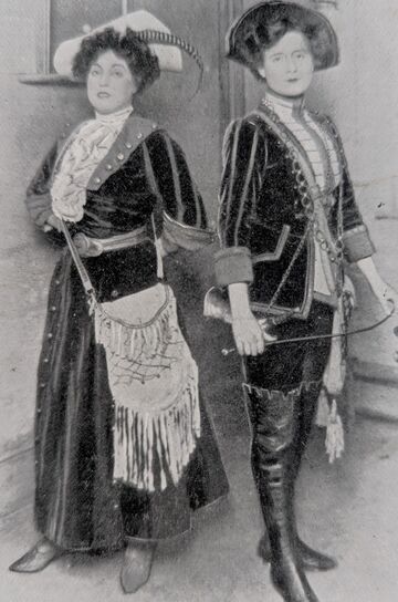 Black and white photograph of two women actors. One of them dressed as a male and the other as female.