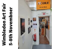 Leather artwork pictures hanging on a wall on the left leading to a studio entrance with a large orange sign above the door saying T Cole Crafts in black, with a red studio number 222.