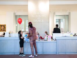 Man and young girl stand at reception, holding a red balloon.