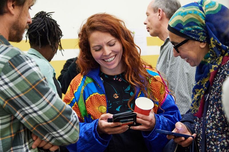 three people stand in a group laughing