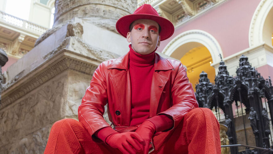 Luca Bosani artist wearing red heat to toe, wide brim hat, trench and turtleneck