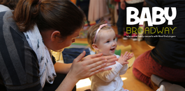 lady with child aged around 1 sitting on the floor clapping together. Baby Broadway logo in top right hand corner