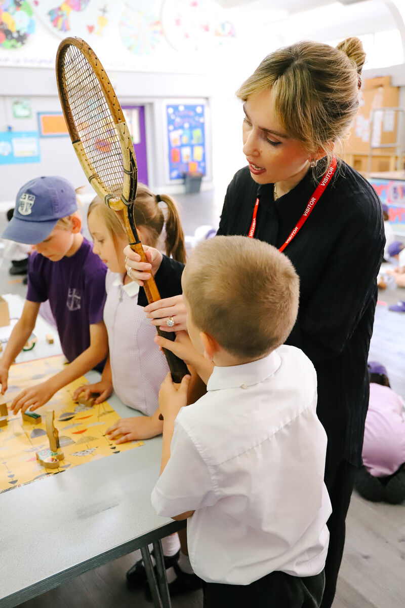 Two children at a table looking at a piece of paper