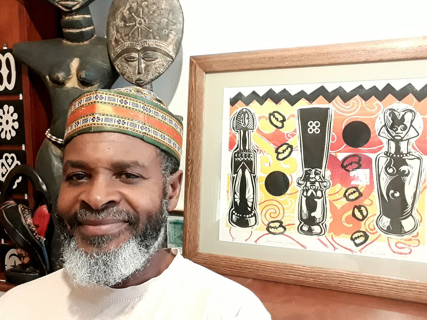 Photo of artist Ken McCalla with his artwork African dolls print