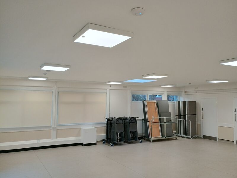 A community space with white blinds and tables