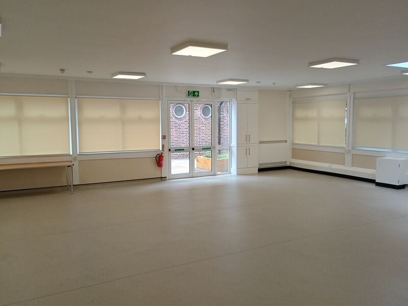 A community space with white blinds and tables
