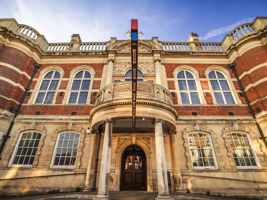 An upward shot of the balcony of Battersea Arts Centre, with the BAC sign jutting out beneath it.