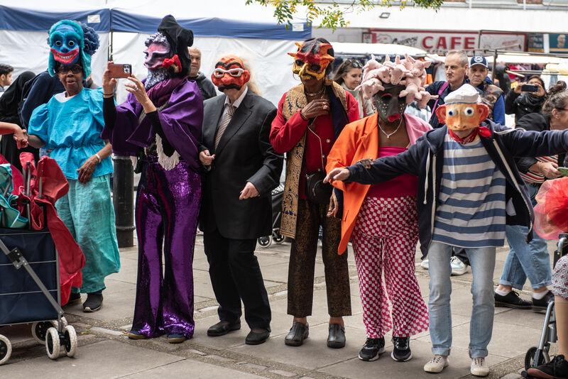 Masked participants standing in a line in The Church Street Masquerade 2024