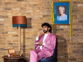 A Man Sits At A Table In Front Of A Wall Picture Of Theresa May