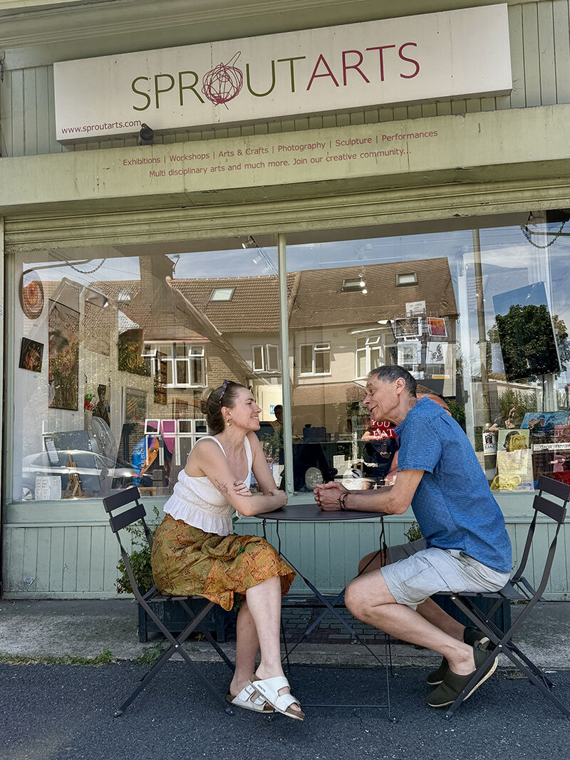 Father and daughter, Crispin and Esme sitting, in conversation, outside Sprout art gallery