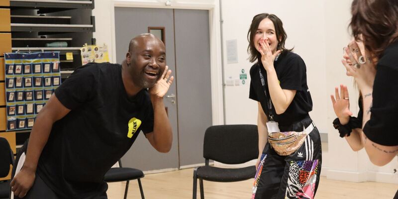 BLINK facilitator Connie smiles broadly at a workshop participant, holding their hand.
