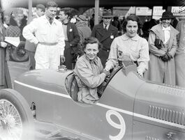 Doreen Evans and Kay Petre at a race, possibly in July 1935, with Doreen sitting in the car and Kay standing beside her