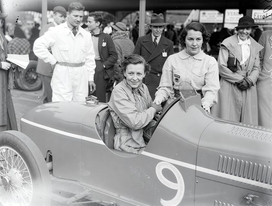 Doreen Evans and Kay Petre at a race, possibly in July 1935, with Doreen sitting in the car and Kay standing beside her