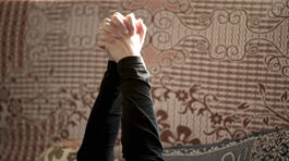 A pair of clasped hands is raised in the air