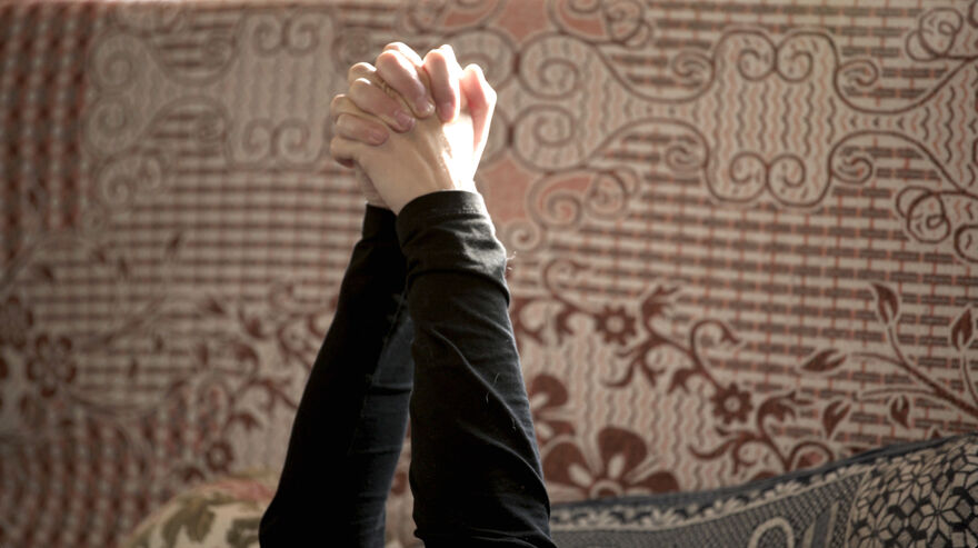 A pair of clasped hands is raised in the air