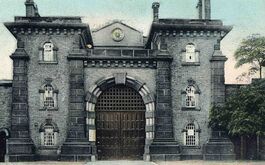 Postcard photographic image showing the gates outside the prison. Wandsworth Libraries & Heritage Service.