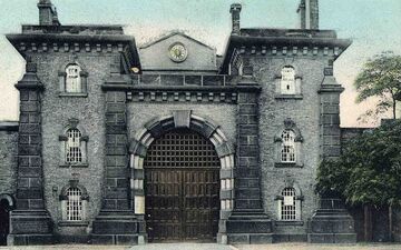 Postcard photographic image showing the gates outside the prison. Wandsworth Libraries & Heritage Service.