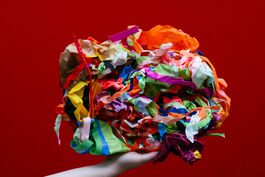 A hand holds a brightly coloured ball of sticky tape