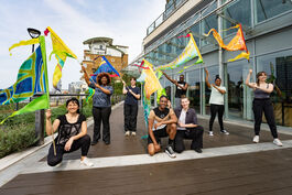 A group of people holding colourful flags