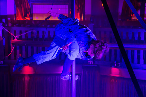 an acrobat performs on a pole