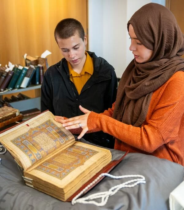 Two people reading a grand old book