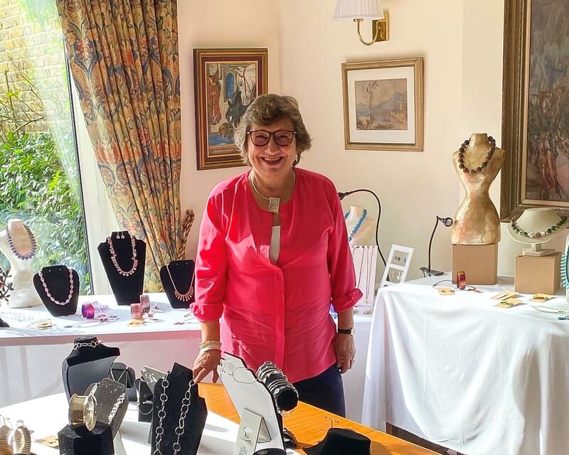 Woman stands behind table of jewellery
