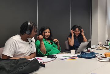 3 people, working and smiling.