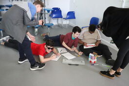 group of teenagers lying on the floor and drawing