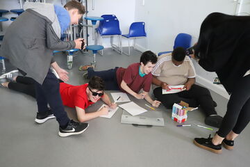 group of teenagers lying on the floor and drawing