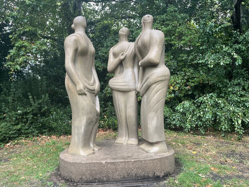 A sculpture of three standing figures located in Battersea Park