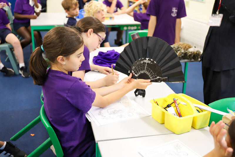 Two children at a table looking at a piece of paper